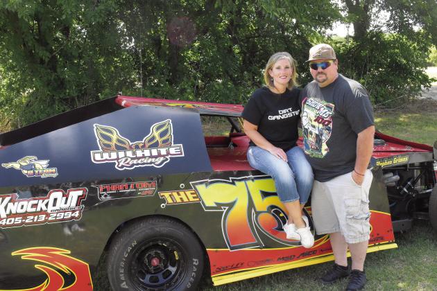 Stephen and Erica Grimes pose along the 75 decal on their race car. Photo/Jentezen Smith